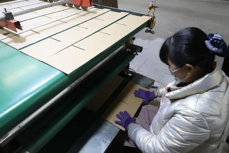 图为香河县佳胜凯利新型包装制品有限公司,工人在对半成品纸箱进行