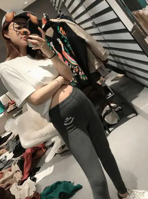 雪梨挺着大肚子,左手拿着手机自拍,右手撩起白色上衣,圆鼓鼓的大肚子