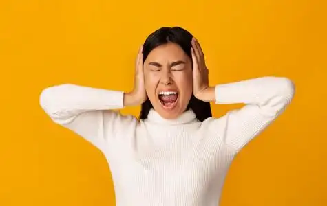 亚洲女孩捂着耳朵大叫照片