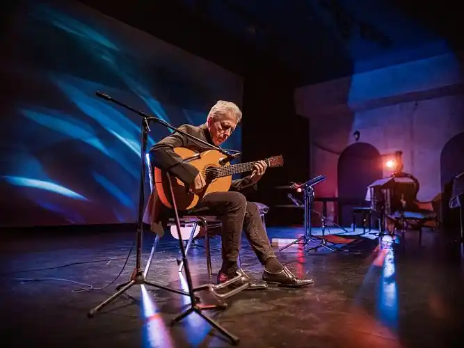 成熟的男吉他手在舞台上演奏古典吉他图片下载