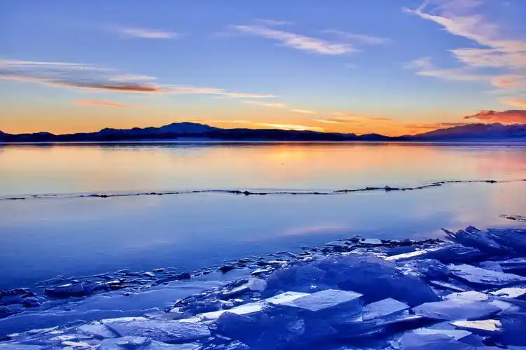 蓝冰之约冬日夕阳下赛里木湖蓝冰覆盖了整个湖面在夕阳的照耀下显得