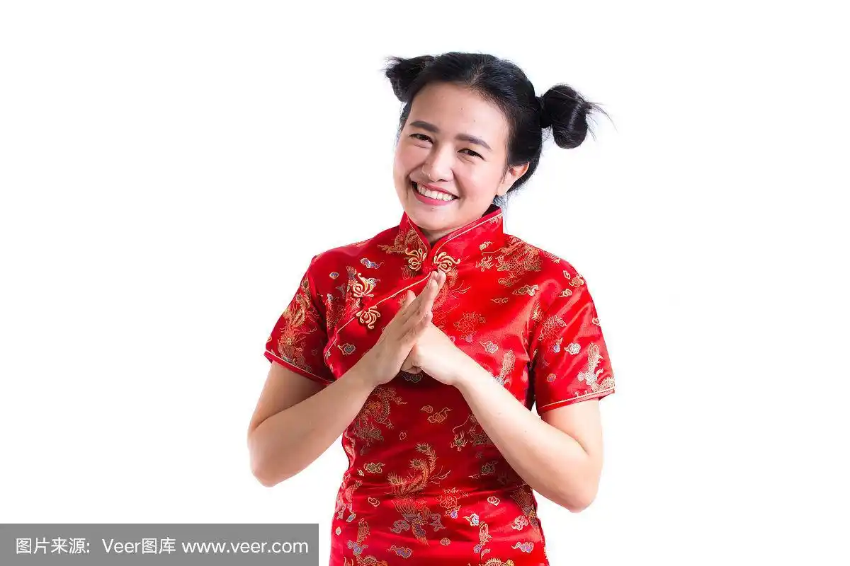 年轻的亚洲妇女穿着中国传统旗袍,用手势表示祝贺,看着镜头微笑在中国