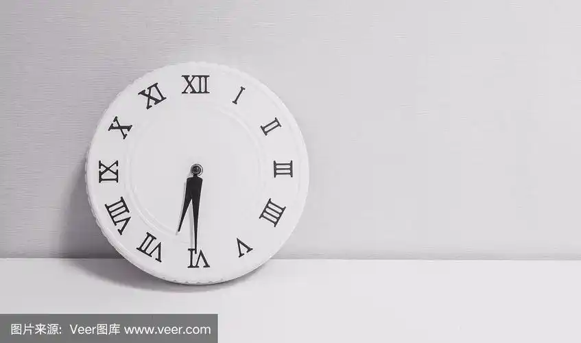 特写白色时钟装饰显示六点半或早上六点半在白色的木桌和壁纸纹理背景