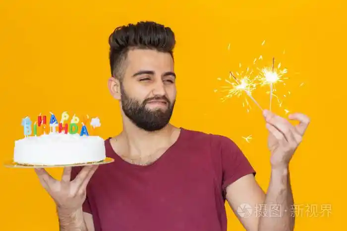 一个留着胡子的年轻男性手里拿着一个写着生日快乐的蛋糕祝贺结婚纪念