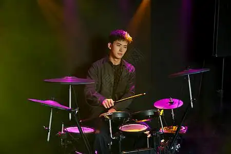年轻帅气男鼓手激情打鼓图片素材