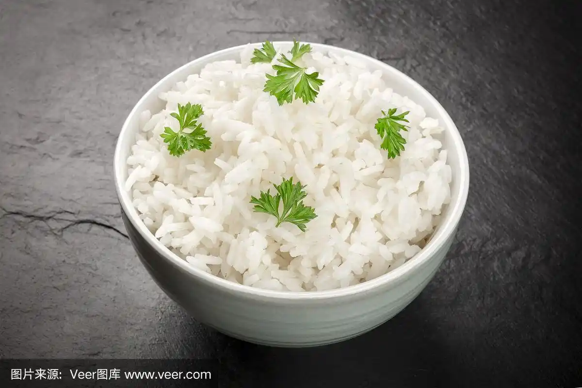一碗煮过的白米饭的照片,在黑色的背景和复制空间
