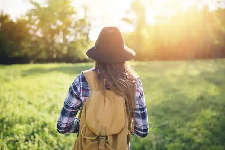 美女在公园草地上行走的背影