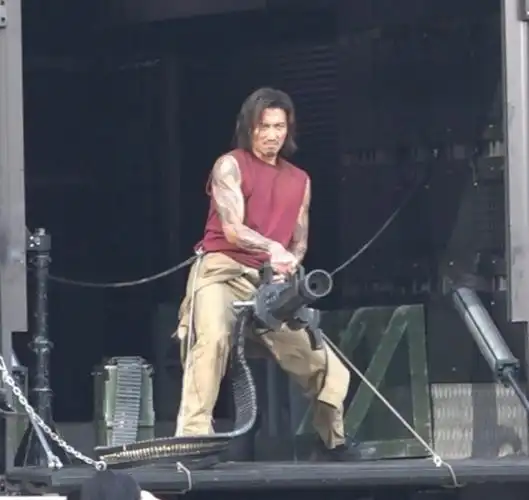 谢霆锋饰演纹身悍匪造型首度曝光,举起火神式机关炮在中环街头向道具