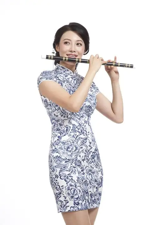 棚拍身穿旗袍的年轻女人吹笛子