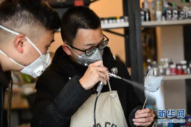 2月4日,在成都市成华区万科路的工作室,曾舟(左)仔细查看模型喷漆上色