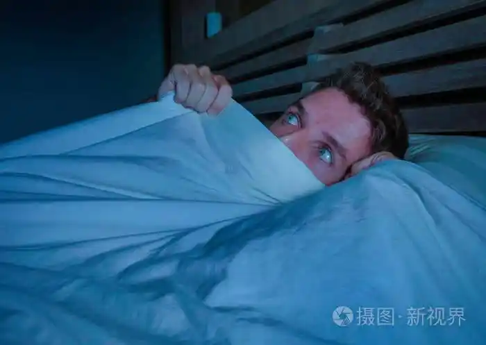 一个年轻迷人的恐惧的惊恐的恐怖的噩梦般的人的肖像用毯子盖着脸晚上