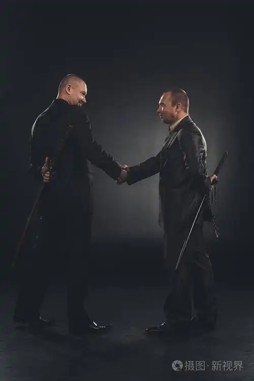 侧视图的黑社会成员握手与刀背后孤立黑色