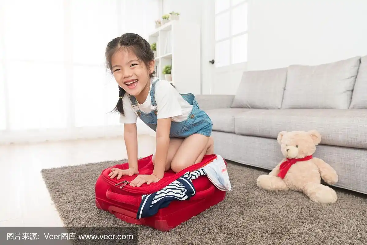 漂亮的小女孩跪在行李箱上