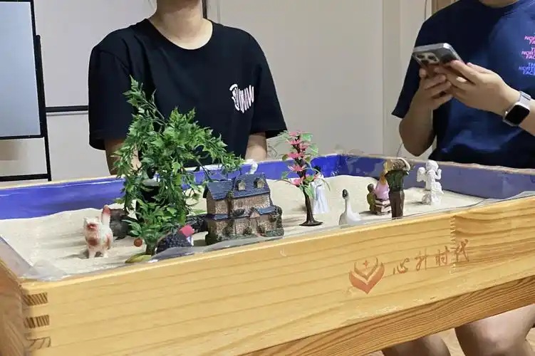 尾声临近游戏结束时,同学们看着沙盘上摆放着沙具的世界,露出了高兴的