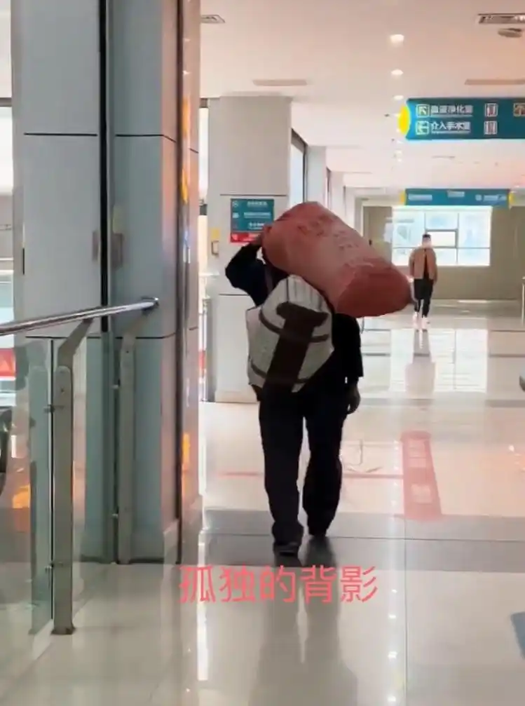 一男子身背行李袋,肩上扛麻袋,走路"摇摇晃晃",令人心酸不已