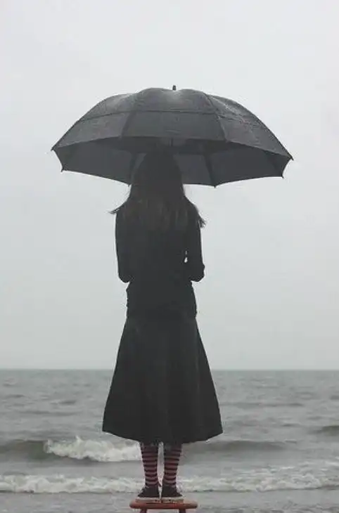 女人雨中撑伞伤心图片