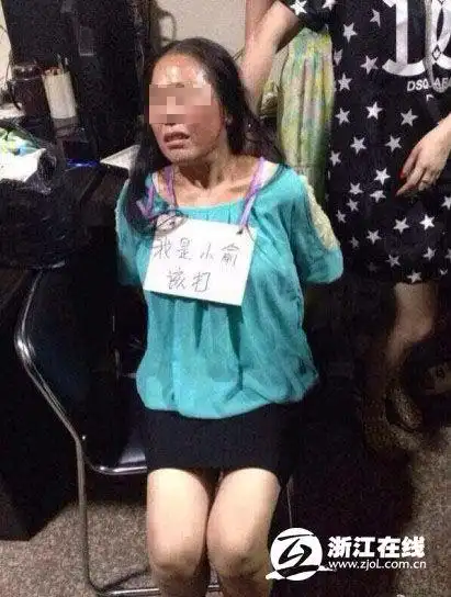 从网友提供的图片来看,女子先是挂了一块写着"我是小偷(偷错写成了"俞