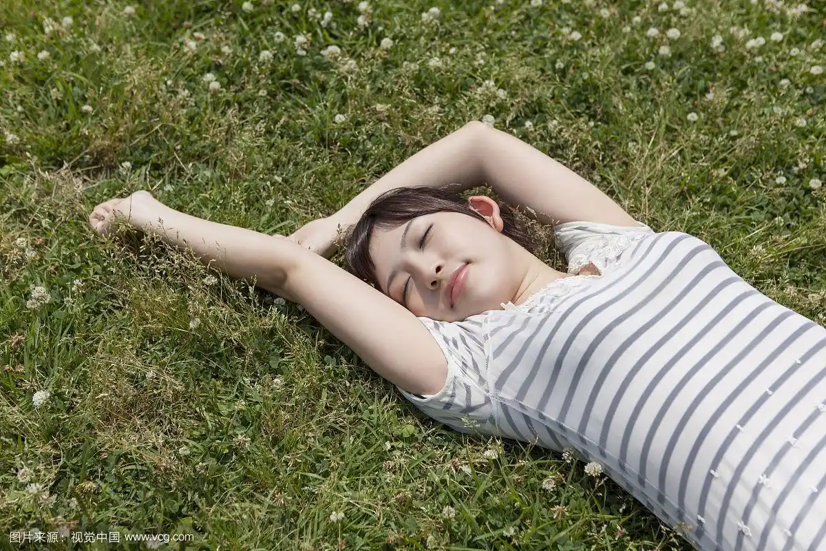 年轻女子躺在草地上休息