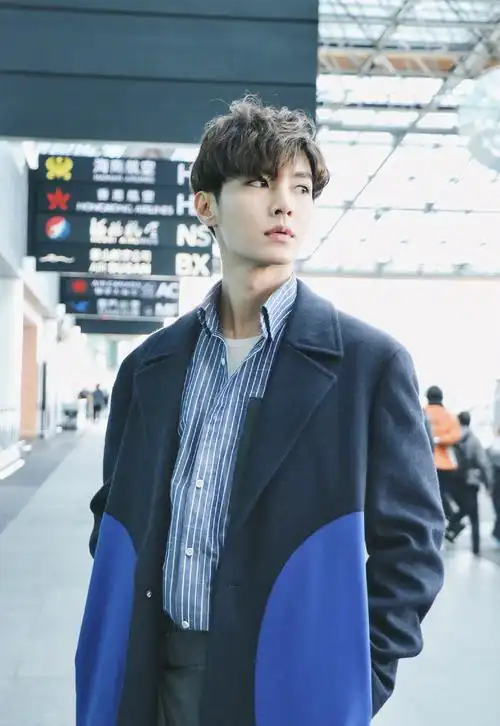 33岁炎亚纶现身机场,换了个波浪发型又穿西装摆酷,状态恢复如初