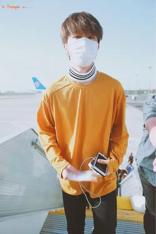 范丞丞戴口罩穿橙色卫衣搭配黑色休闲裤现身机场难道脖子不热吗