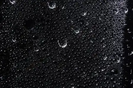 透明塑料薄膜黑色背景上的宏滴图片素材