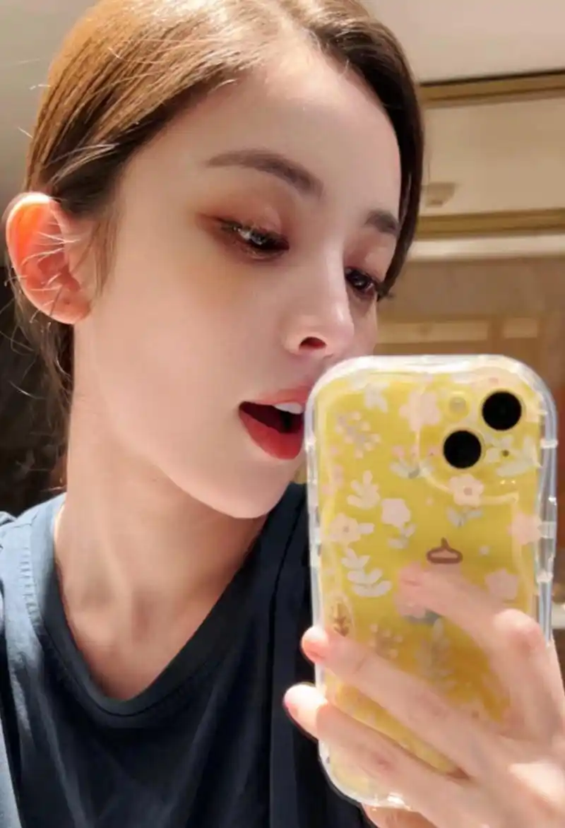 娜扎拿手机对着镜子自拍,侧脸线条尽显精致明星范,她的日常照片几乎都