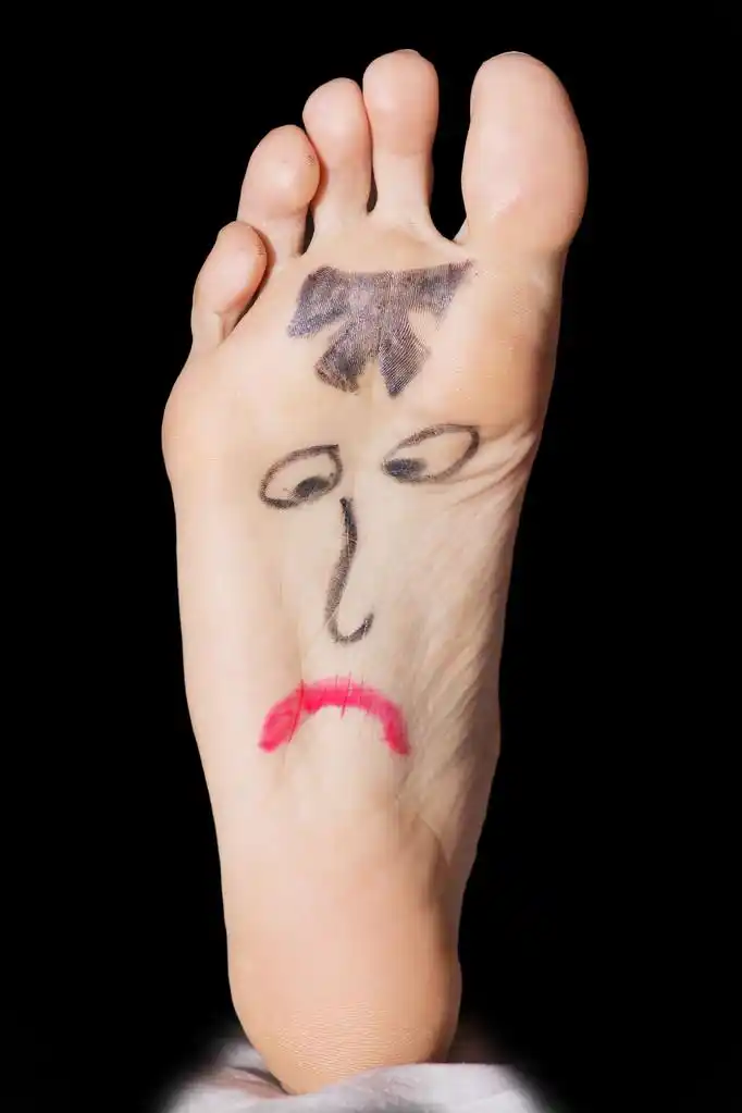 在女人的脚上画悲伤的脸