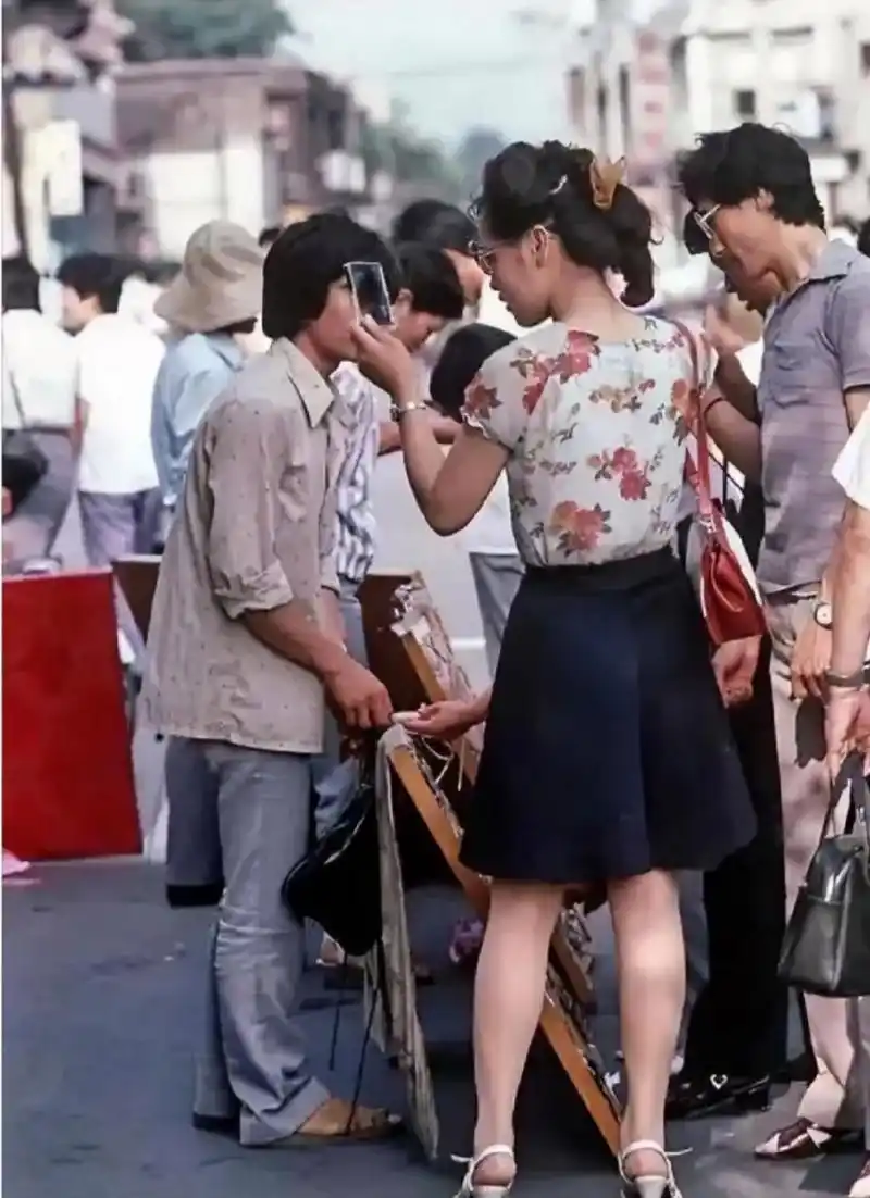 二十世纪八十年代,某城市街头老照片,在一个卖墨镜的摊位,一位穿着