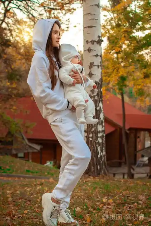 美丽的年轻妈妈带着孩子在秋天