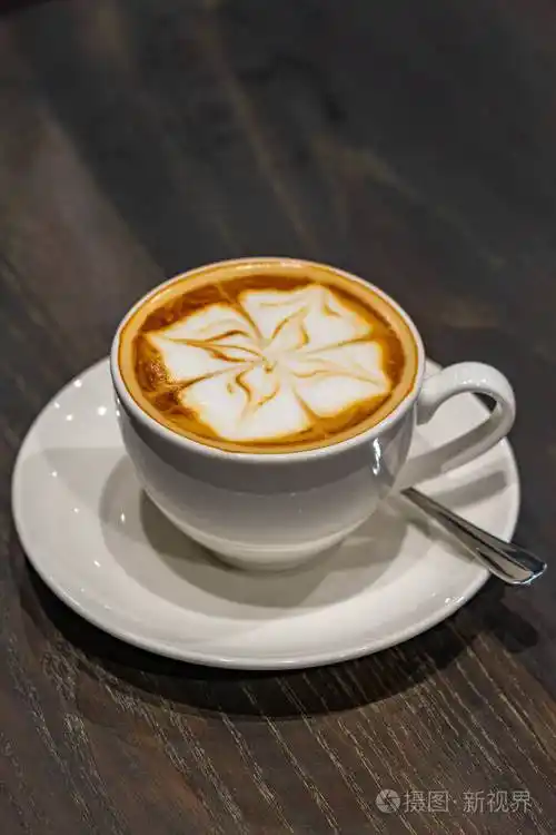 木质背景上美丽的卡布奇诺泡沫牛奶艺术咖啡