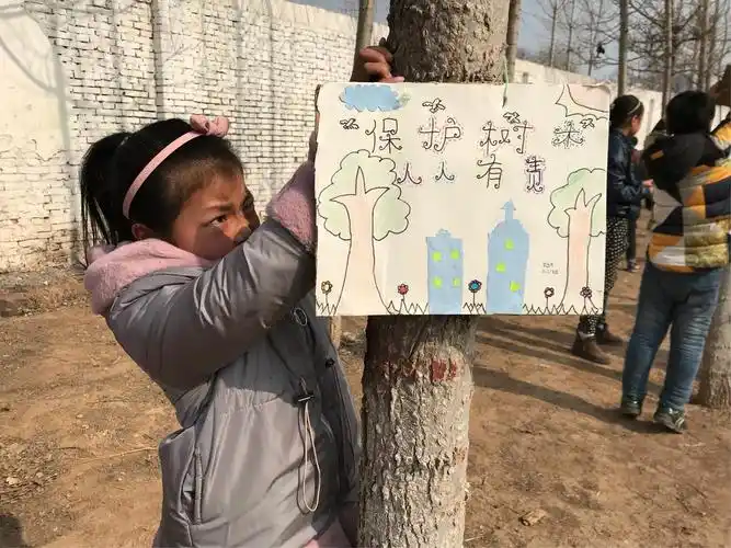 3.12日植树节 三一班学生为小树挂牌保护树木