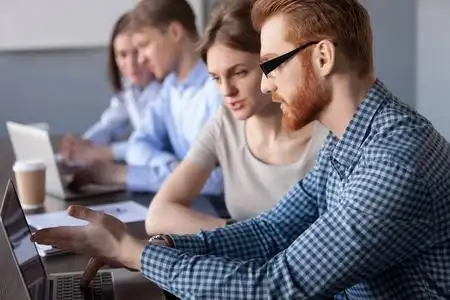 专注认真的同事一起讨论电脑照片