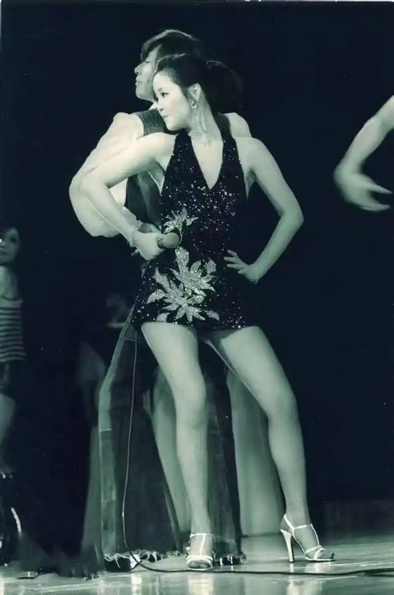照片中的邓丽君一袭深v短裙,脚穿白色的高跟鞋,和舞伴贴身热舞,尽显