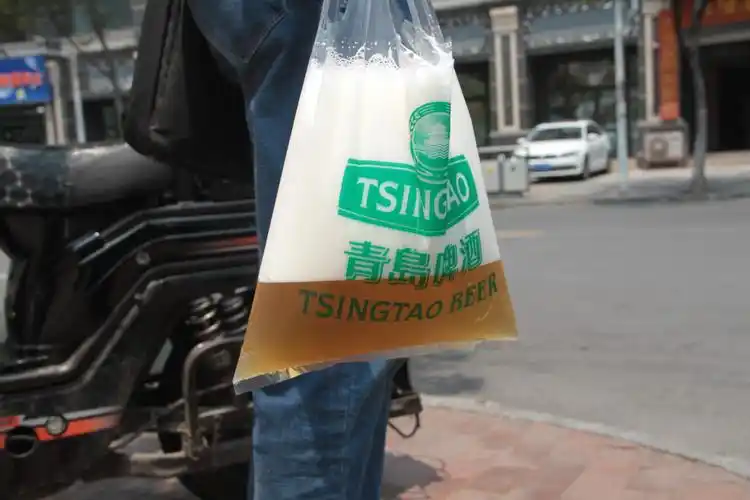 原创青岛小袋装啤酒走红女游客边走边用吸管喝