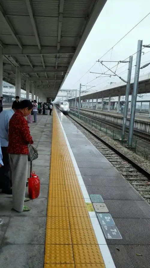 来到站台,与时麾人站一起等待高速火车,火车从远方