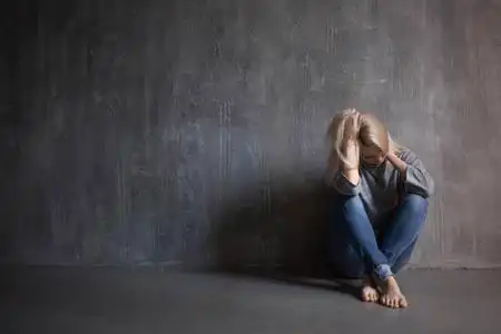 悲伤的女人坐在地板上.抑郁症和慢性疲劳.