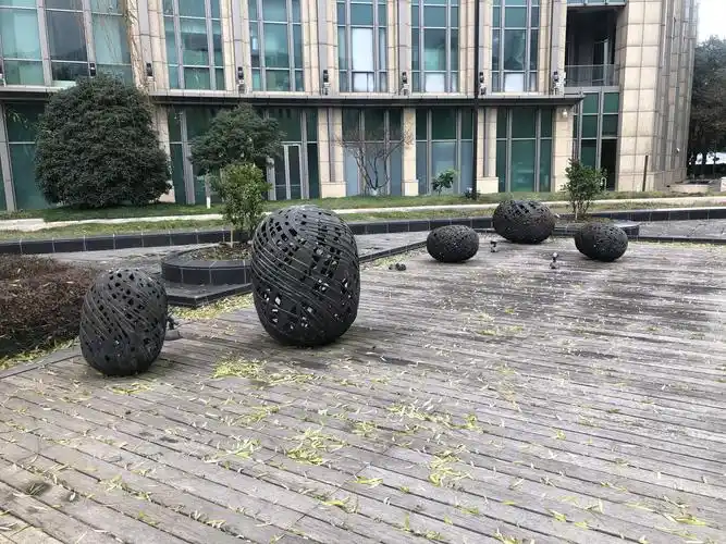 木平台上的小雕塑也是与正门的雕塑相呼应的蚕茧形象.