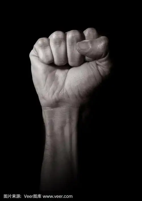 一名男子在黑色背景上握紧拳头