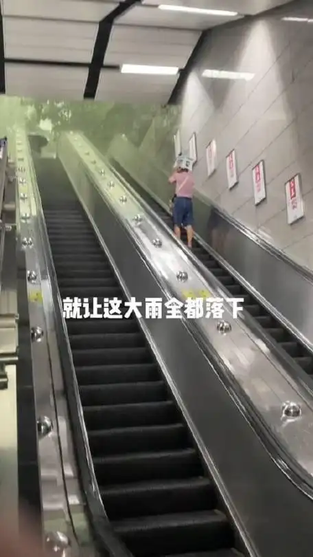 近日雷风暴雨横扫广东一位阿叔出地铁扶梯上用小凳子挡雨