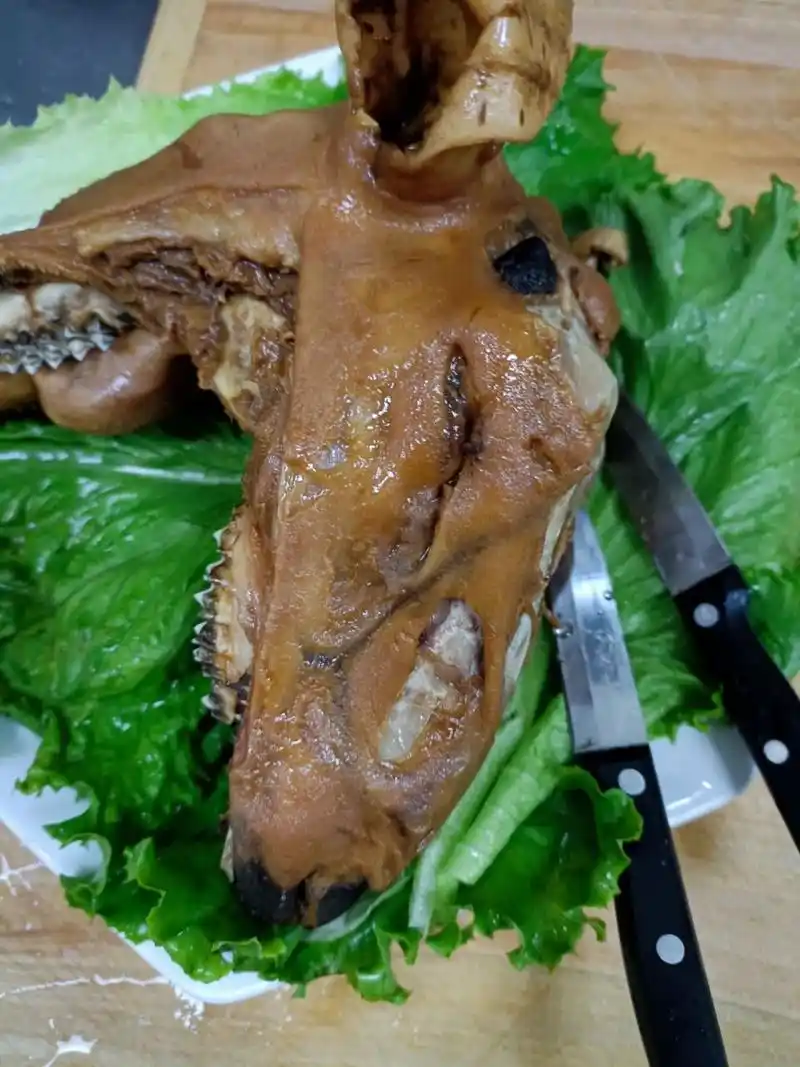 羊头洗净下锅或配卤汁汤料卤煮,可整的手把羊头也可配上蒜汁做成羊头