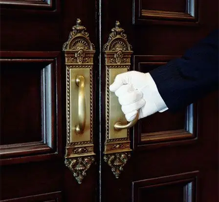 戴着白手套的男人的手拉开门