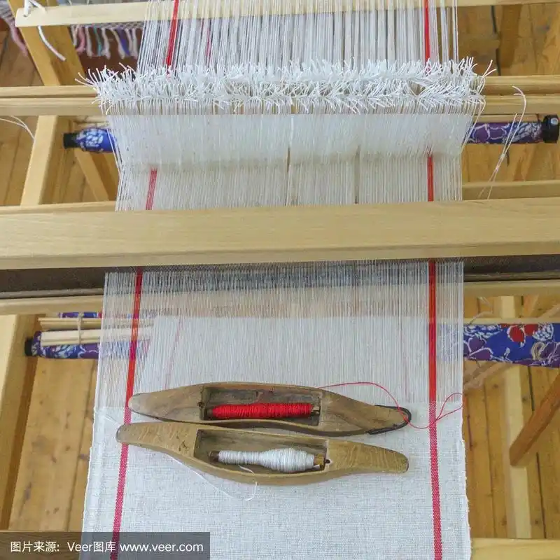 织布机上亚麻线的木梭和轴.在亚麻布上编织梭子.