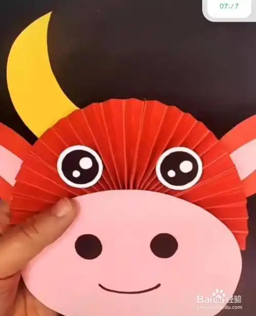 黄色卡纸剪成两个月牙状,粘贴在牛头的两边对应位置.