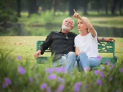 两个快乐的老年人退休,男人和女人坐在公园里聊天照片