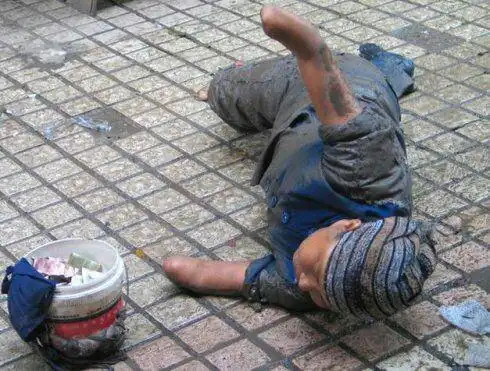 的桥头或繁华的步行街看到一个或者两个可怜的残疾人跪在冰冷的地面上