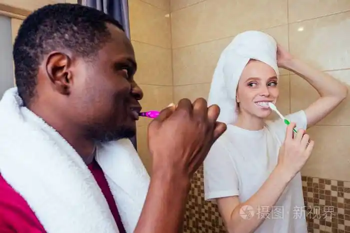 非洲裔美国人男女洗澡后用毛巾包着湿头发上班前刷牙