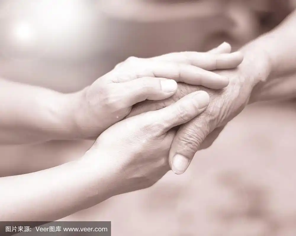 临终关怀中,照顾者牵着老人的手.慈善慈善对残疾人的慈善理念.