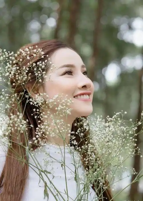 手捧鲜花,身穿白色奥黛,气质温婉,笑容阳光的国外姑娘真美