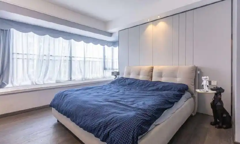 主卧温馨舒适,床头背景墙的不规则硬包线条划分,使整个空间简洁素雅.