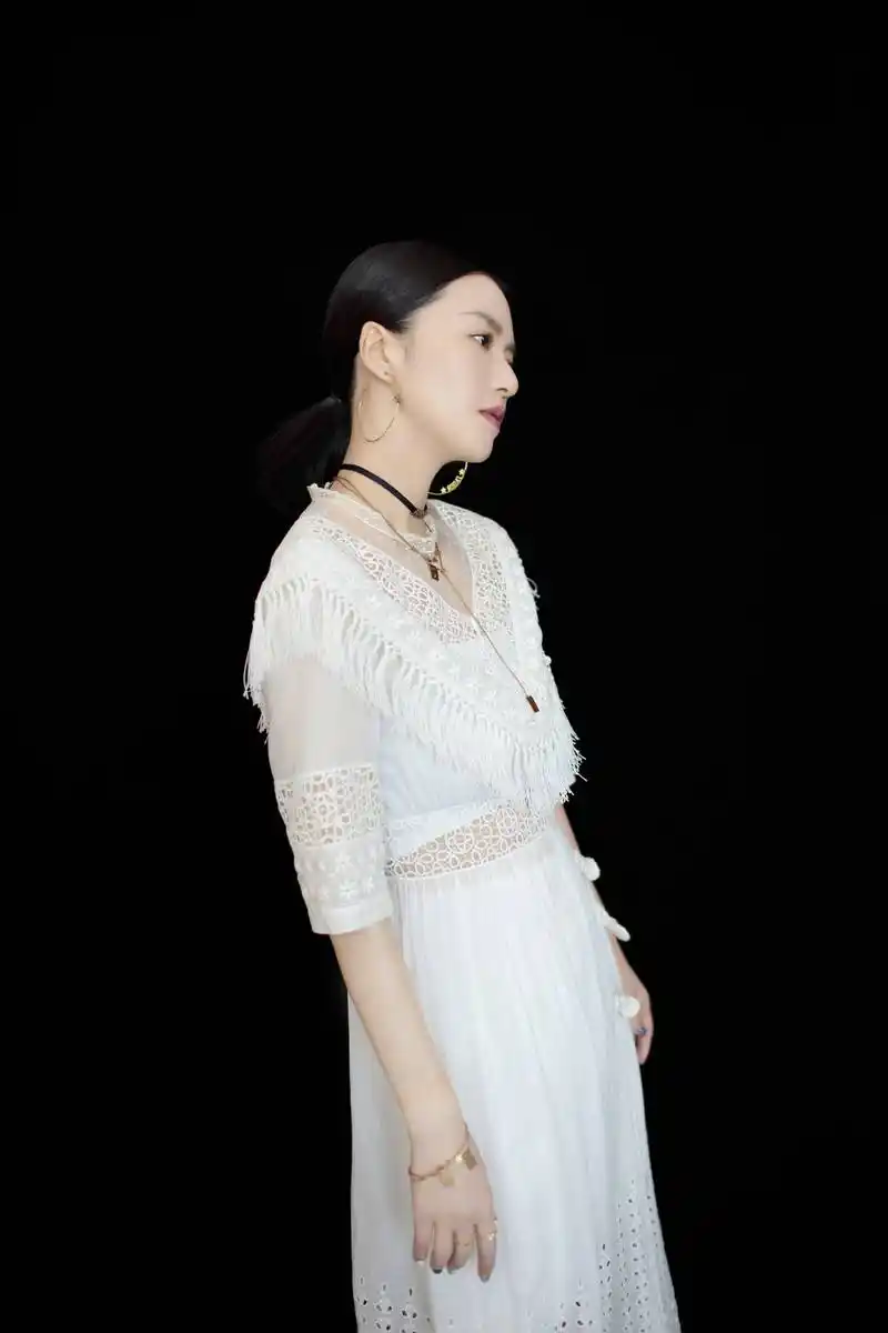 谭维维身着白色镂空长裙展露翩翩优雅气息,流苏设计彰显别致韵味
